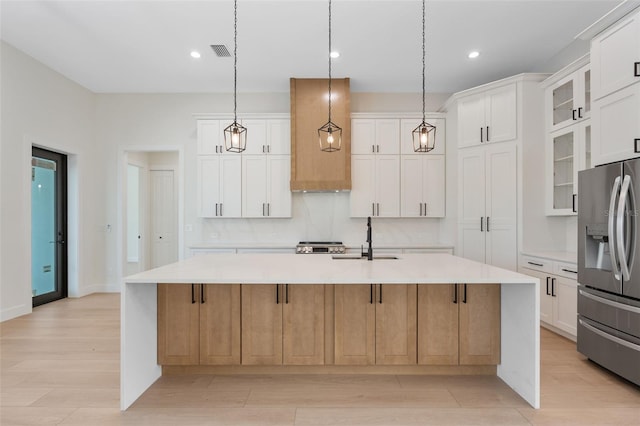 117 Marker Rd, Rotonda West, FL 33947 - kitchen with stainless steel refrigerator with ice dispenser, a sink, light countertops, a spacious island, and light wood-type flooring
