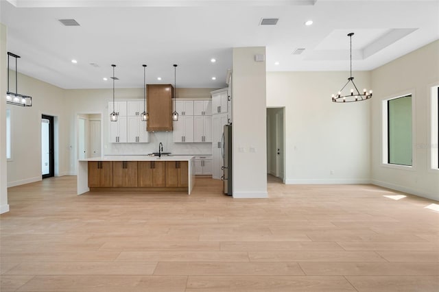 117 Marker Rd, Rotonda West, FL 33947 - kitchen with freestanding refrigerator, open floor plan, light countertops, a chandelier, and light wood finished floors