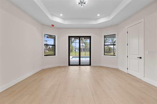 117 Marker Rd, Rotonda West, FL 33947 - empty room featuring a raised ceiling, light wood-style floors, baseboards, and recessed lighting