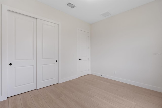 117 Marker Rd, Rotonda West, FL 33947 - unfurnished bedroom with light wood-style flooring, baseboards, and a closet