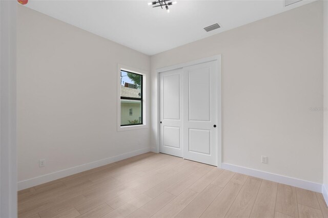 117 Marker Rd, Rotonda West, FL 33947 - unfurnished bedroom featuring baseboards, light wood-type flooring, and a closet