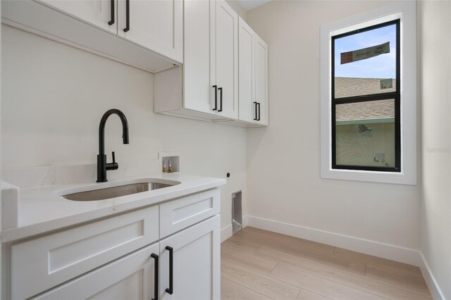 117 Marker Rd, Rotonda West, FL 33947 - clothes washing area with washer hookup, light wood finished floors, cabinet space, baseboards, and hookup for an electric dryer