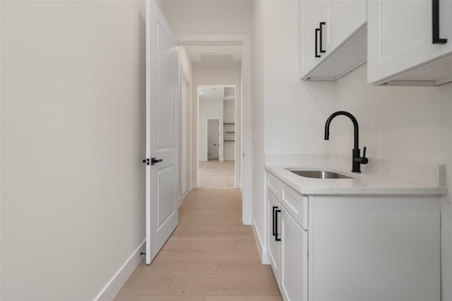117 Marker Rd, Rotonda West, FL 33947 - bar featuring a sink, light wood-type flooring, and baseboards