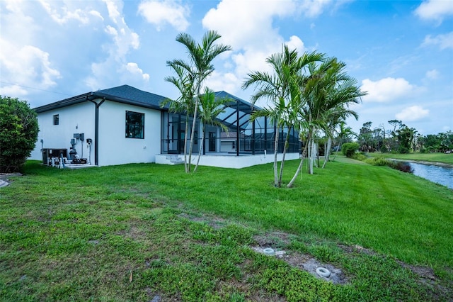 117 Marker Rd, Rotonda West, FL 33947 - rear view of property with stucco siding, a yard, glass enclosure, and a water view