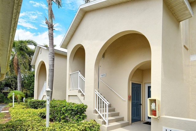 doorway to property featuring stucco siding