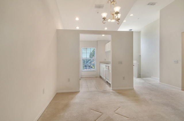 spare room featuring recessed lighting, light carpet, a chandelier, and baseboards