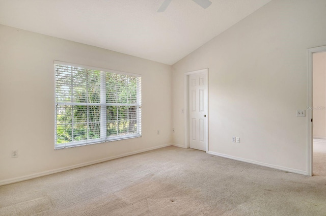 carpeted spare room featuring lofted ceiling, baseboards, and ceiling fan