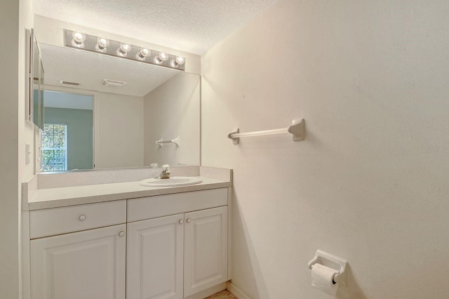 bathroom featuring a textured ceiling and vanity