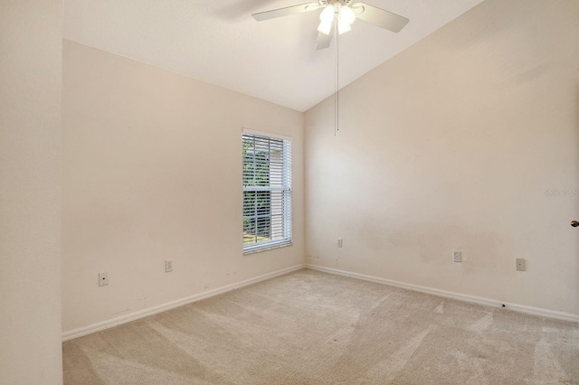 spare room with light colored carpet, a ceiling fan, baseboards, and high vaulted ceiling