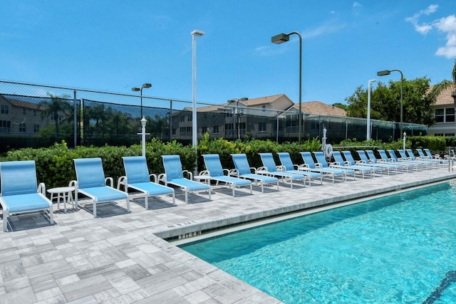 community pool with fence and a patio