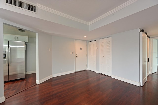 2901 26th St W Unit 312, Bradenton, FL 34205 - unfurnished bedroom featuring stainless steel fridge, crown molding, dark wood-style flooring, two closets, and a barn door