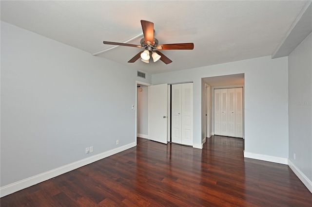 2901 26th St W Unit 312, Bradenton, FL 34205 - unfurnished bedroom with baseboards, wood finished floors, two closets, and a ceiling fan