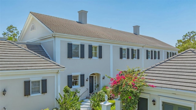33 Bishops Court Rd Unit 118, Osprey, FL 34229 - back of property featuring a tile roof, stucco siding, and a chimney