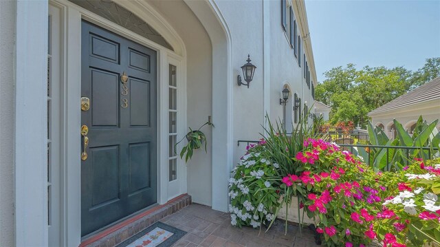 33 Bishops Court Rd Unit 118, Osprey, FL 34229 - view of exterior entry featuring stucco siding and covered porch