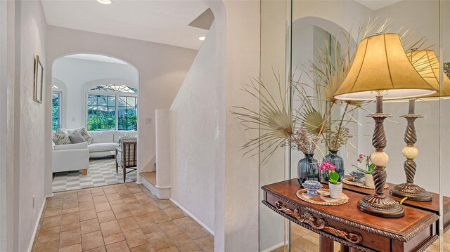 33 Bishops Court Rd Unit 118, Osprey, FL 34229 - hallway with arched walkways, baseboards, stairs, and recessed lighting