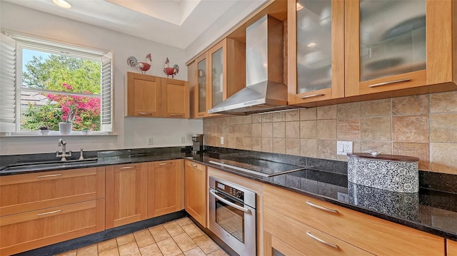 33 Bishops Court Rd Unit 118, Osprey, FL 34229 - kitchen with stainless steel oven, wall chimney exhaust hood, a sink, black electric stovetop, and dark stone countertops