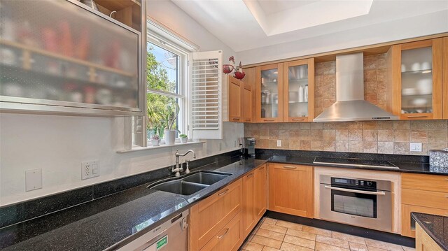 33 Bishops Court Rd Unit 118, Osprey, FL 34229 - kitchen featuring stainless steel appliances, wall chimney exhaust hood, a sink, tasteful backsplash, and dark stone counters