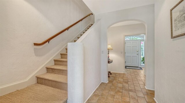 33 Bishops Court Rd Unit 118, Osprey, FL 34229 - entryway with arched walkways, stone finish floors, baseboards, stairway, and a textured wall