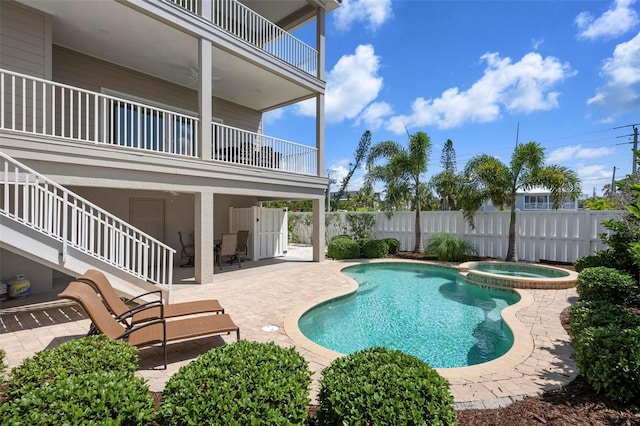 view of swimming pool with fence, a patio area, and a pool with connected hot tub