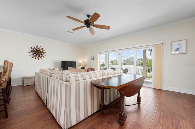 living room featuring hardwood / wood-style floors, ornamental molding, baseboards, and a ceiling fan