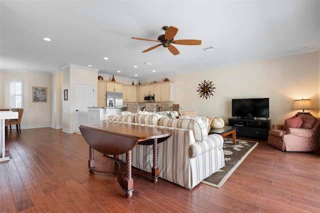 living area featuring a ceiling fan, ornamental molding, hardwood / wood-style floors, baseboards, and recessed lighting