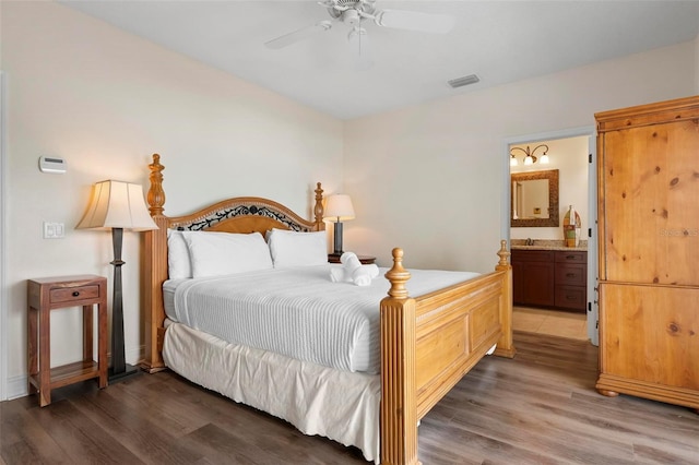 bedroom with light wood-style floors, ensuite bath, a ceiling fan, and a sink