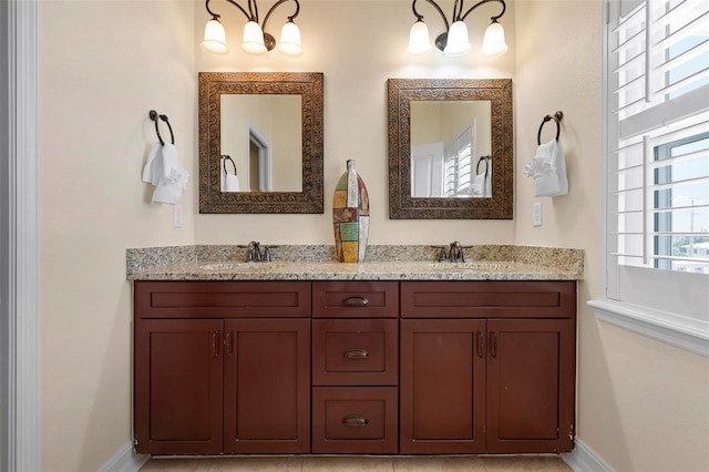 full bathroom with baseboards, double vanity, and a chandelier