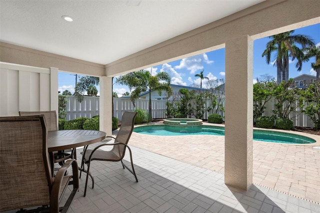 view of pool featuring a patio area, a fenced backyard, and a pool with connected hot tub