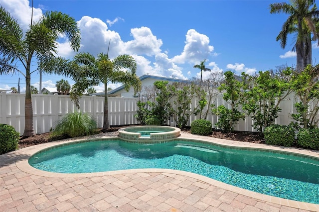 view of swimming pool featuring fence and a pool with connected hot tub