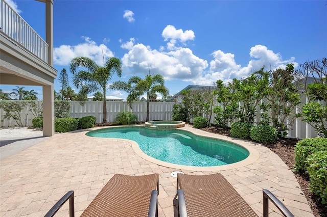 view of swimming pool with a patio area, a fenced backyard, and a pool with connected hot tub