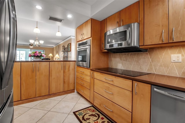 10423 Waterbird Way Unit 10423, Bradenton, FL 34209 - kitchen featuring appliances with stainless steel finishes, decorative backsplash, a chandelier, dark countertops, and brown cabinetry