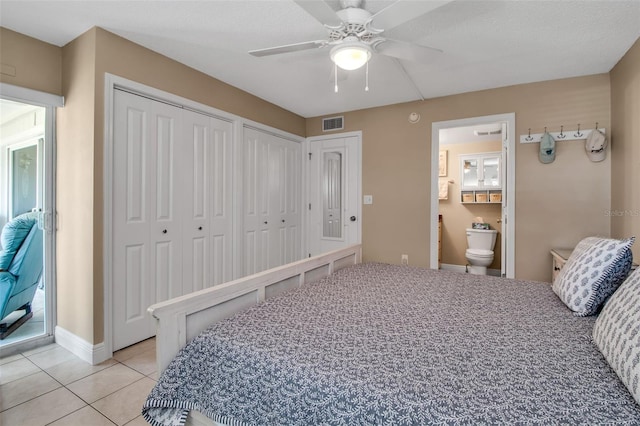 10423 Waterbird Way Unit 10423, Bradenton, FL 34209 - bedroom featuring multiple closets, light tile patterned floors, ensuite bathroom, a ceiling fan, and baseboards