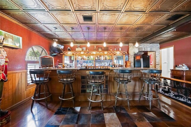 4225 Ulman Ave, North Port, FL 34286 - community bar area with freestanding refrigerator, an ornate ceiling, a wainscoted wall, wooden walls, and dark wood-type flooring