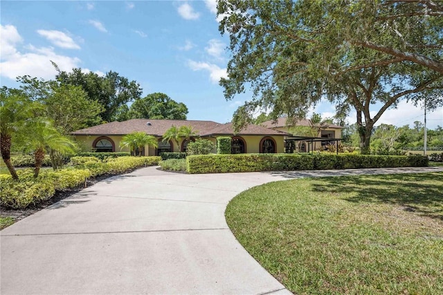 4225 Ulman Ave, North Port, FL 34286 - ranch-style home featuring curved driveway, stucco siding, and a front yard