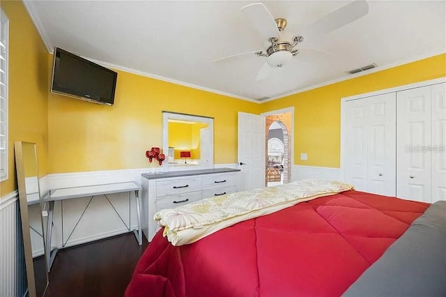 4225 Ulman Ave, North Port, FL 34286 - bedroom featuring dark wood-style flooring, a wainscoted wall, ornamental molding, a closet, and a ceiling fan
