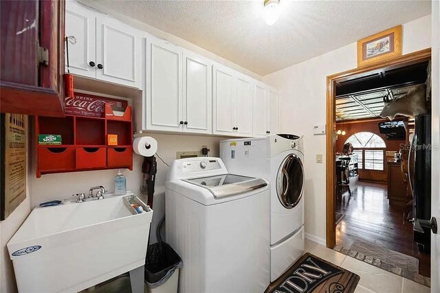 4225 Ulman Ave, North Port, FL 34286 - laundry room with washing machine and clothes dryer, cabinet space, a textured ceiling, and tile patterned flooring