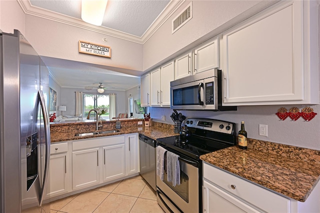 kitchen featuring stainless steel appliances, crown molding, a sink, white cabinets, and light tile patterned floors