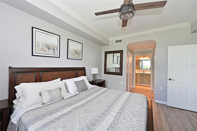 bedroom featuring light wood-style floors, ornamental molding, baseboards, connected bathroom, and ceiling fan