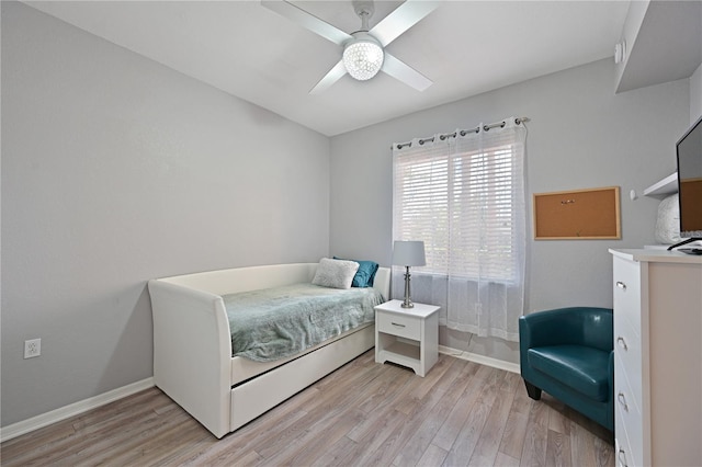 bedroom featuring light wood-style floors, baseboards, and a ceiling fan