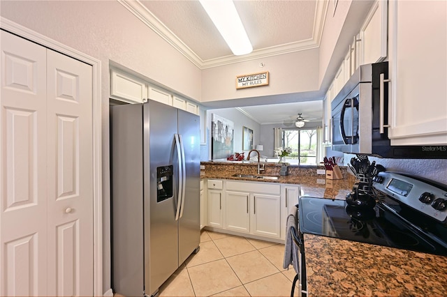 kitchen with appliances with stainless steel finishes, a sink, ornamental molding, light tile patterned flooring, and white cabinetry