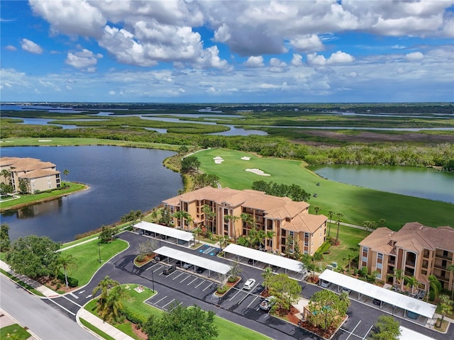 drone / aerial view of a nearby body of water and a local golf course