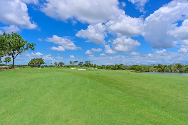 surrounding community with golf course view and a water view