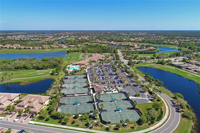 aerial view of property and surrounding area featuring a large body of water and nearby suburban area