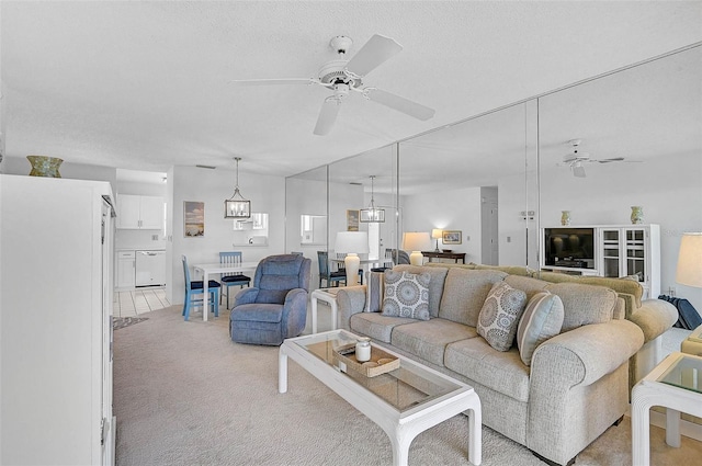 living room featuring ceiling fan, light colored carpet, and a textured ceiling