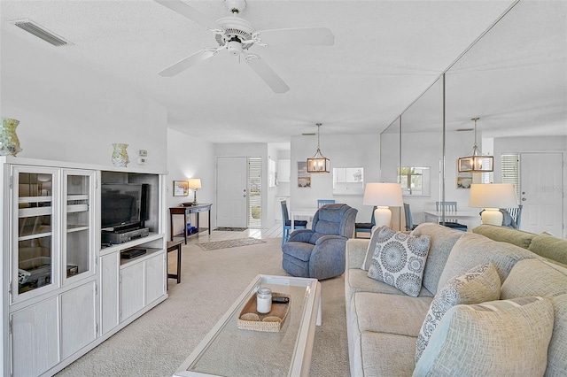 living area featuring light colored carpet, healthy amount of natural light, and ceiling fan