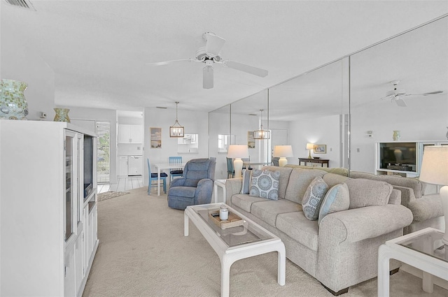 living room with ceiling fan and light colored carpet