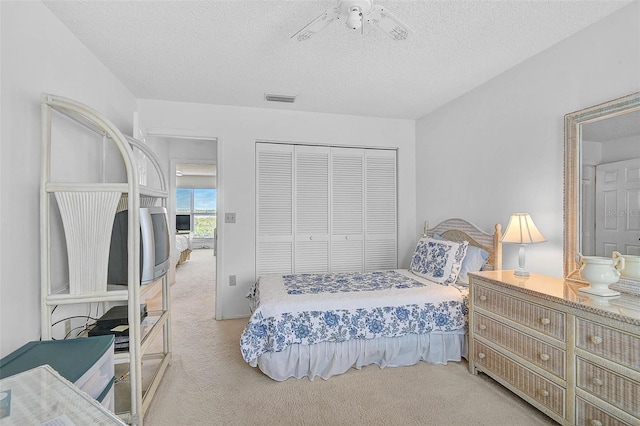 carpeted bedroom featuring a closet and a textured ceiling