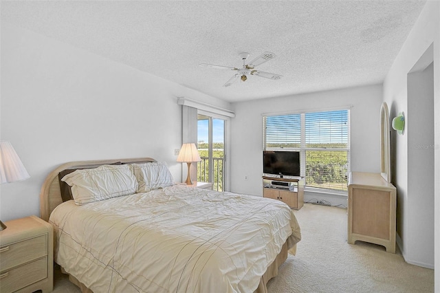 carpeted bedroom with access to outside, a textured ceiling, and ceiling fan