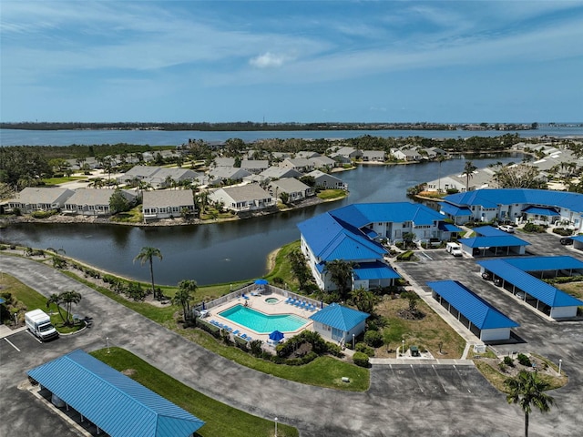 aerial perspective of suburban area featuring a large body of water and a pool