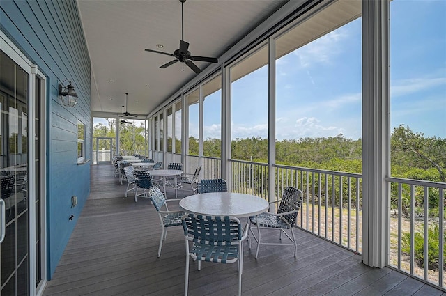 sunroom featuring ceiling fan, outdoor dining area, and plenty of natural light